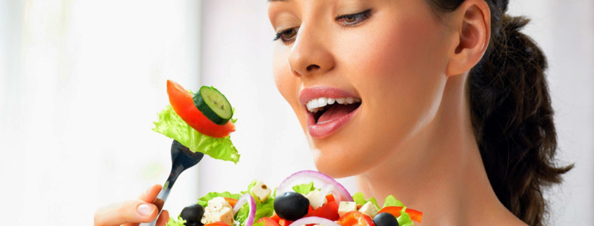 dieta ipocalorica, una donna mangia un piatto con alimenti sani