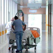 malattie rare, cad, ricoveri: corridoio di un ospedale con operatore che trasporta letto