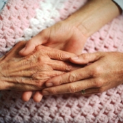 cure palliative, un medico stringe le mani di una donna