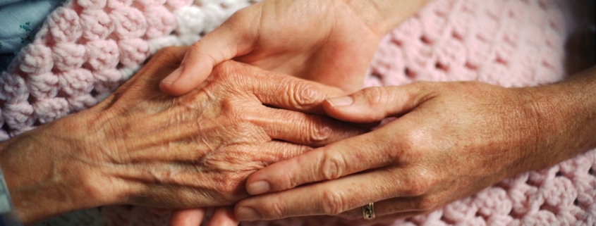 cure palliative, un medico stringe le mani di una donna