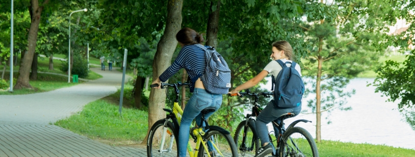 salute, due ragazzi in bici in un parco di città