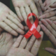 virus hiv e aids, mani con fiocco rosso