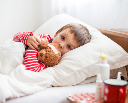 cancro pediatrico, un bambino a letto con un pupazzo di peluche tra le braccia