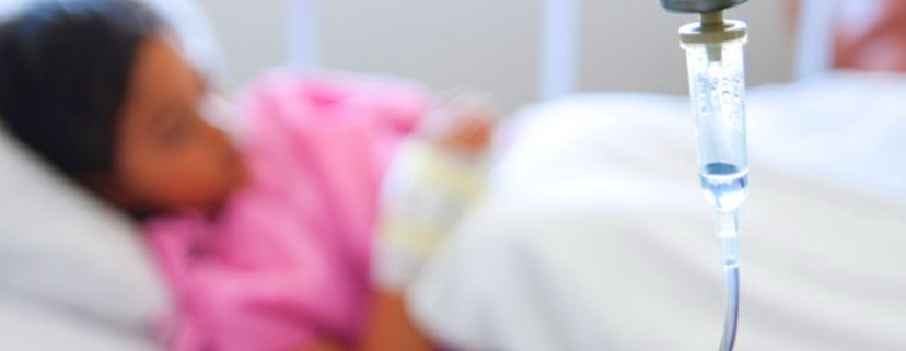 una bambina malata di tumore in un letto di ospedale
