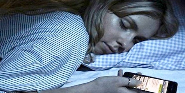10 consigli efficaci per dormire bene. nella foto una donna dorme con il cellulare in mano