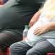 stimolazione magnetica transacranica, la tecnica indolore che riduce desiderio di cibo .obesità, due persone in evidente sovrappeso