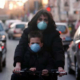 malattie respiratorie croniche: madre in bici con bimbo e mascherina in città