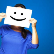 stress da isolamento, donna mantiene un cartello con un sorriso disegnato