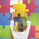 autismo, un bambino inserisce la tessera di un puzzle