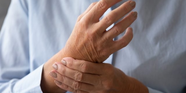 artrite reumatoide, un uomo si stringe il polso
