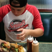 alimentazione, un adolescente mangia un panino non sano