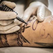 tatuaggi, un uomo si fa tatuare il braccio