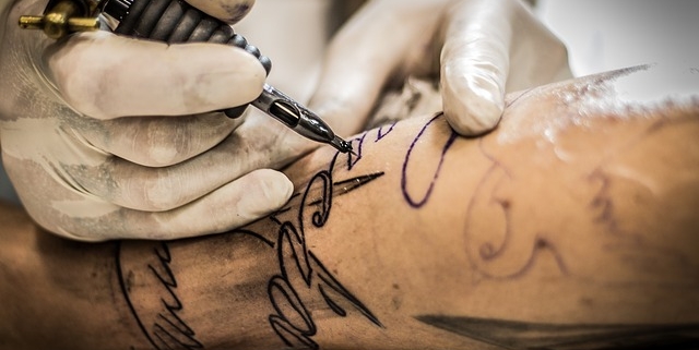 tatuaggi, un uomo si fa tatuare il braccio