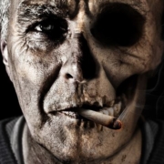 il volto di un uomo che fuma tabacco è rappresentato come mezzo teschio