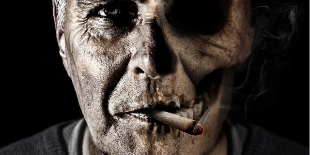 il volto di un uomo che fuma tabacco è rappresentato come mezzo teschio