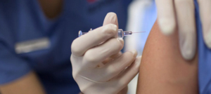 prevenzione. vaccino influenza, medico inserisce ago in un braccio