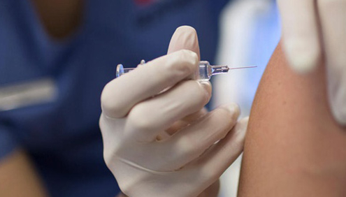 vaccino influenza, medico inserisce ago in un braccio