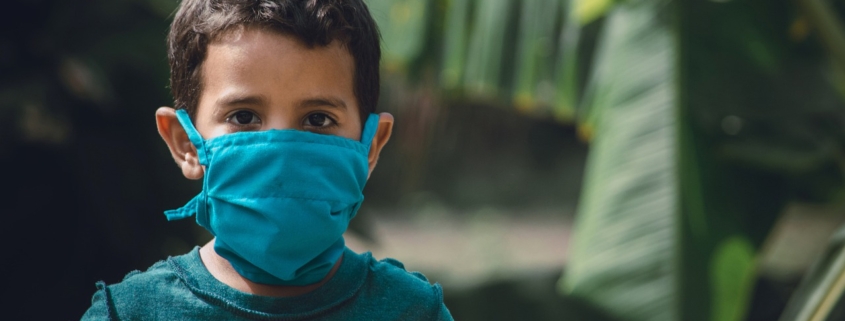 vaccinazione, un bambino indossa la mascherina