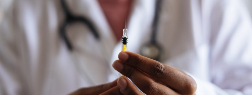 covid e vaccini mrna: un medico prepara siringa per vaccino