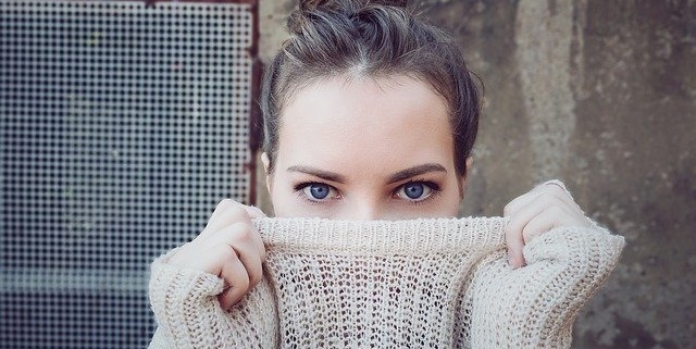 una donna nasconde il volto dietro il maglione