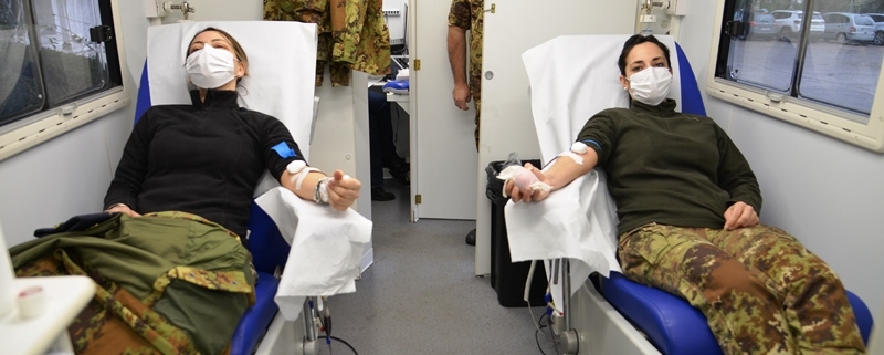 due donne in divisa donano il sangue