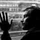 ansia e depressione, un uomo in bianco e nero appoggiato su un vetro mentre fuori piove