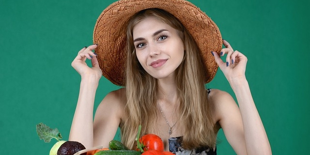 pomodoro, una donna con un cappello di paglia e della verdura e ortaggi sul tavolo davanti a lei