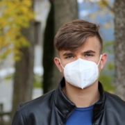 vaccini, un giovane indossa la mascherina