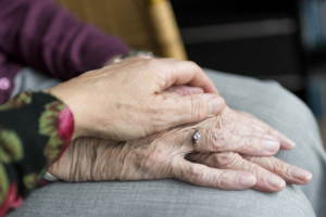 anziani e solitudine. paziente cronico, una mano caregiver su un'altra mano di un'anziana