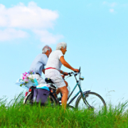 due anziani in bicicletta in una zona verde della città