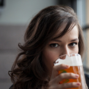 alcol e tumori. giovane donna sta bevendo un boccale di birra