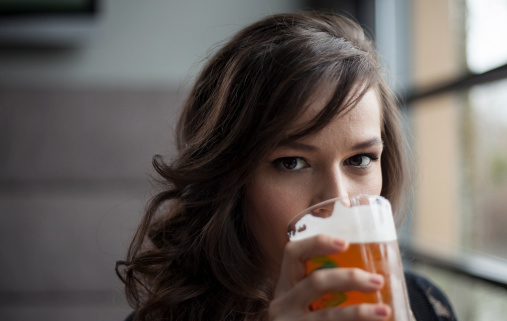 alcol e tumori. giovane donna sta bevendo un boccale di birra