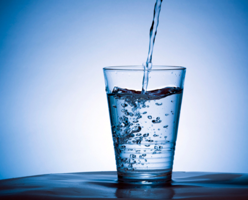 pfas nell'acqua potabile contaminata, un bicchiere nel quale viene versata acqua