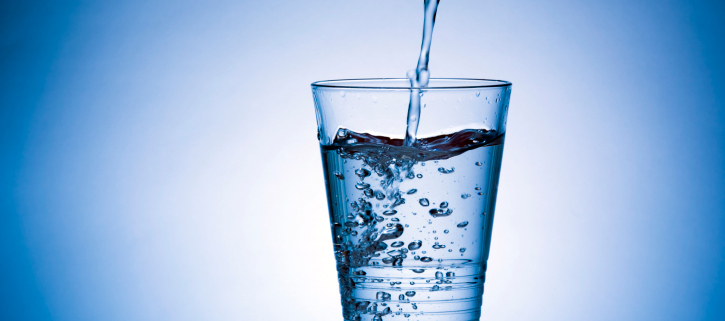 ritenzione idrica, un bicchiere nel quale viene versata acqua
