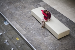 insonnia e melatonina, una donna in pigiama con un cuscino seduta su una panchina