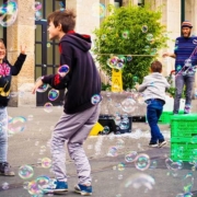 bambini giocano con bolle in città