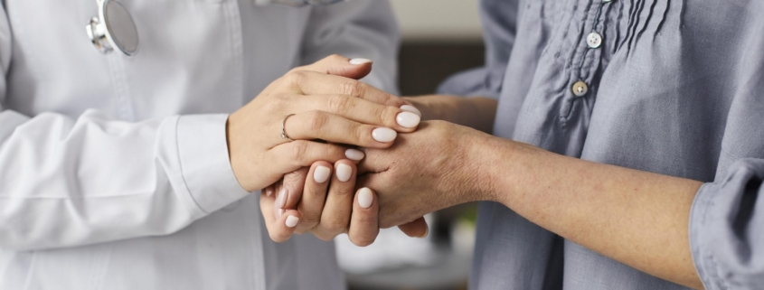 tumore metastatico, pazienti oncologici, mani di un medico stringono quelle di una paziente