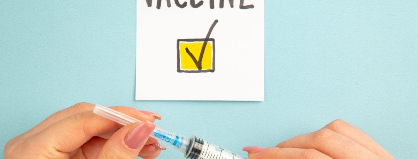 fragilità severa e covid: vista-dall-alto-vaccino-nota-scritta-da-donna-su-sfondo-blu-vaccino-colore-