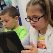 balbuzie, due bambini usano tablet e smartphone