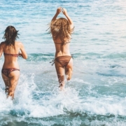 infezioni da spiaggia, ecco come proteggersi, nella foto due donne che corrono in mare.