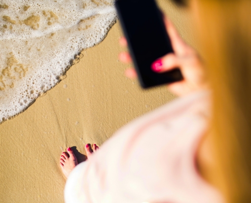 diabete, ragazza in spiaggia con dispositivo in mano sulla riva