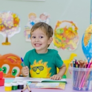 rientro a scuola un bimbo sorride mentre colora un disegno