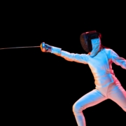 teen girl in fencing costume with sword in hand isolated on black background diabete