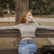 inquinamento, una giovane donna con la maschera seduta su una panchina