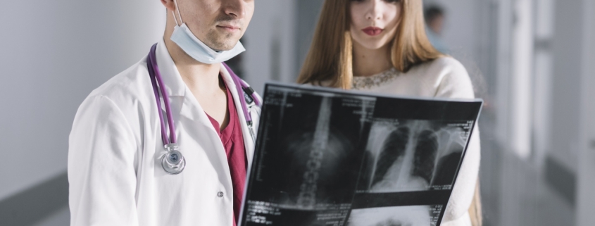 osteoporosi, due giovani medici osservano una radiografia