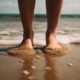 verruca, un ragazzo con i piedi nella sabbia