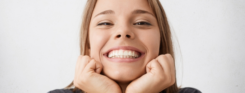 una giovane donna mostra i denti con un sorriso smagliante