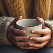 mani e piedi freddi, una donna tiene una tazza calda