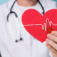 prevenzione: una dottoressa tiene in mano un cuore con il tracciato di un elettrocardiogramma