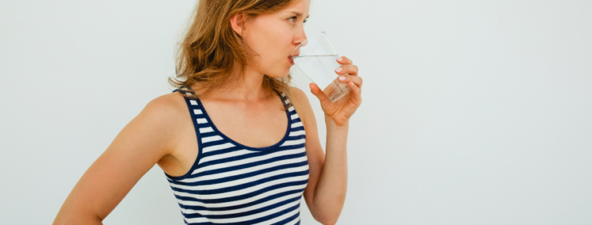 donna con bicchiere di vetro mentre beve